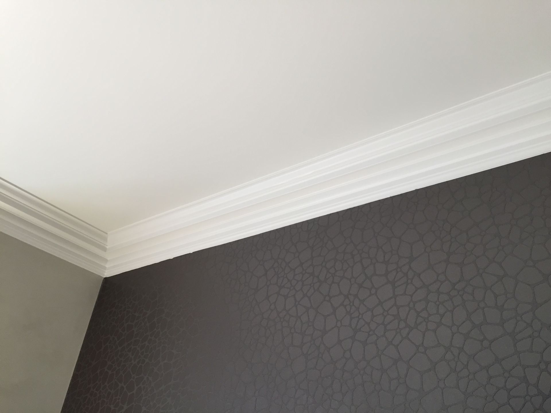 Ein Raum mit weißer Decke und schwarzer Wand.