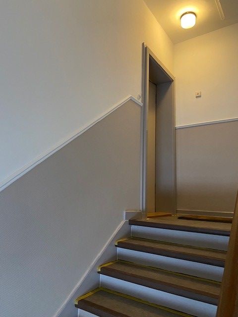 Eine Treppe, die zu einer Tür in einem Gebäude führt.