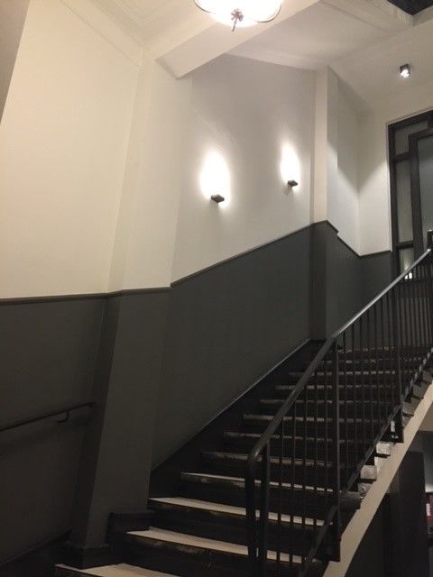 Eine Treppe in einem Gebäude mit einem schwarzen Geländer