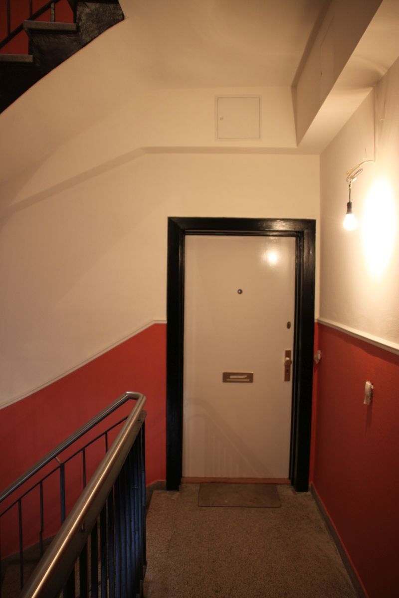 Ein Flur mit einer weißen Tür und roten Wänden