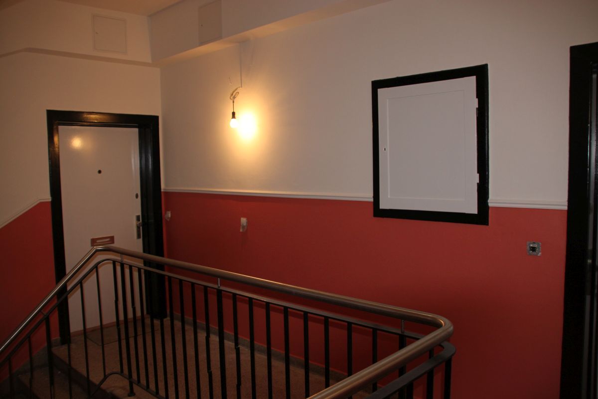Eine Treppe mit roten und weißen Wänden und einem schwarzen Geländer
