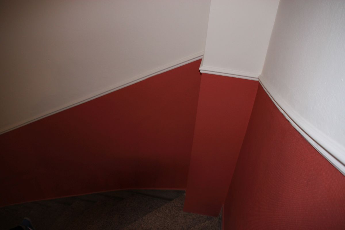 Eine Treppe mit roten und weißen Wänden und einem weißen Geländer.