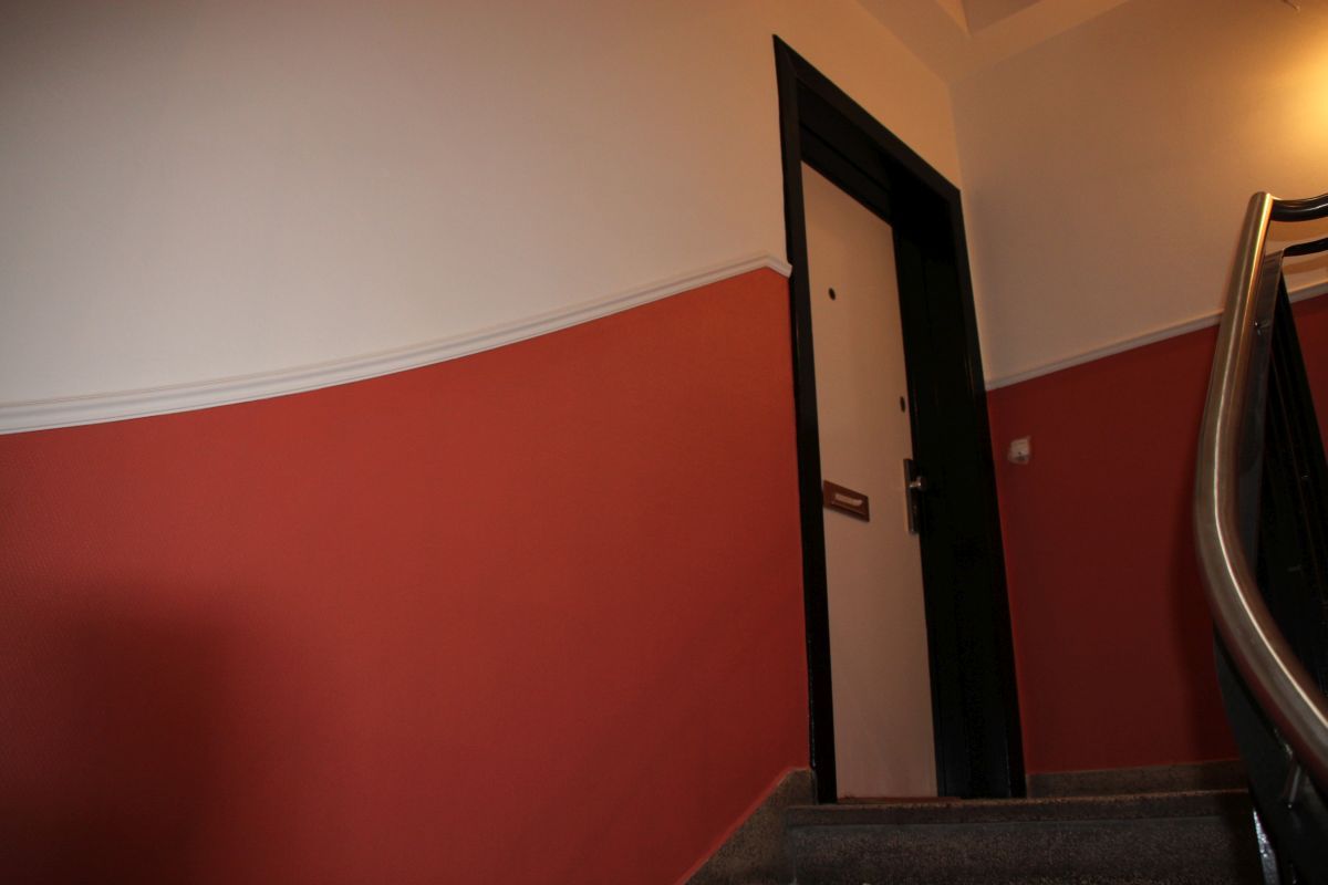 Eine Treppe mit roten und weißen Wänden und einer Tür