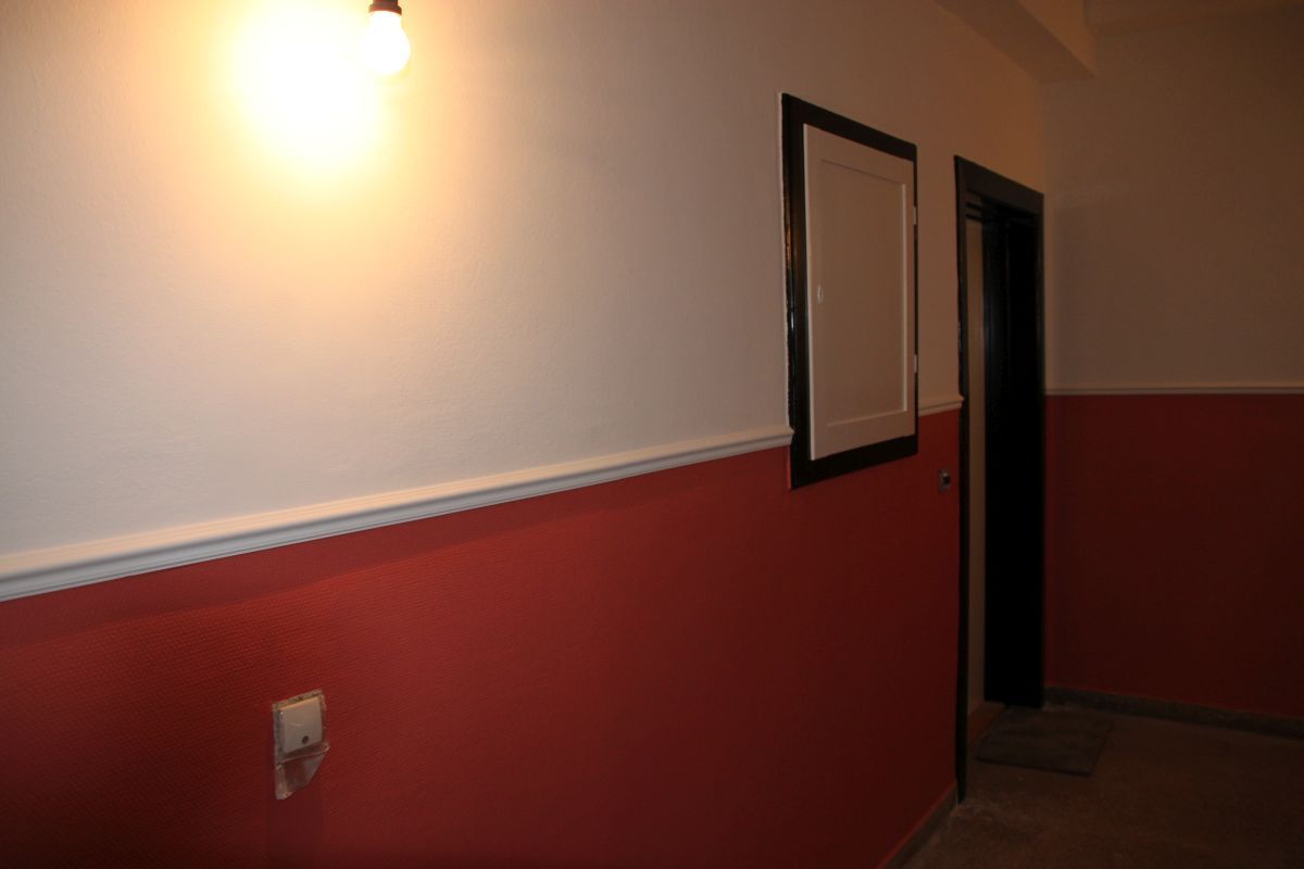 Ein Flur mit roten und weißen Wänden und einer Tür