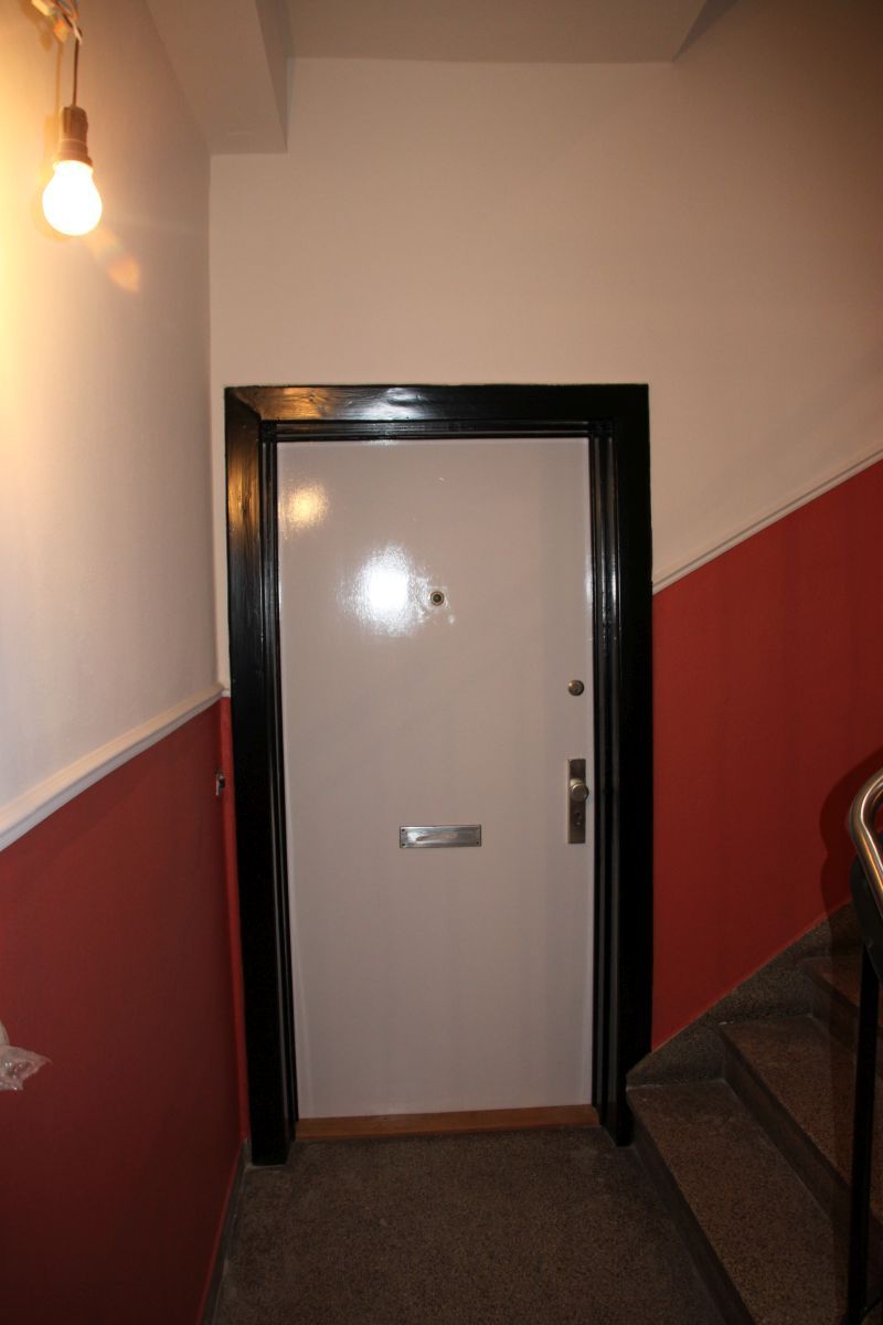 Eine weiße Tür in einem Flur neben einer Treppe