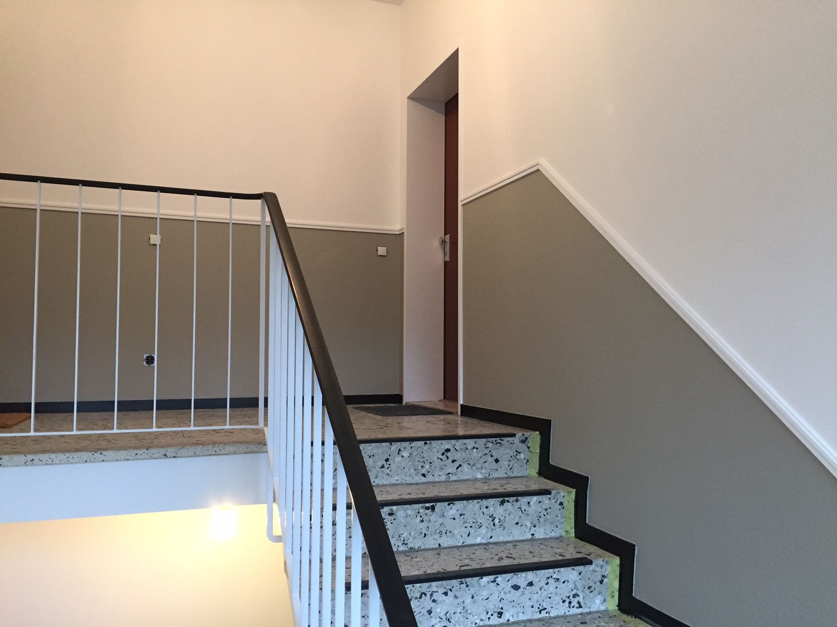 Eine Treppe mit einem weißen Geländer und einer Tür