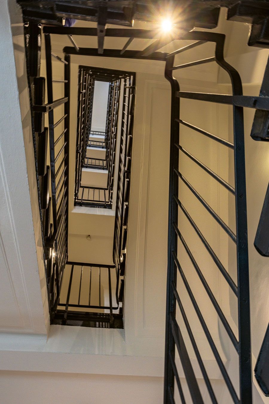 Blick auf eine sehr lange Treppe mit einem schwarzen Geländer