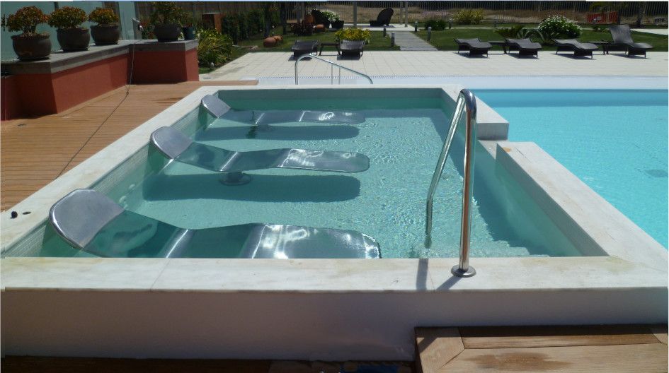 Una gran piscina con sillas en ella.