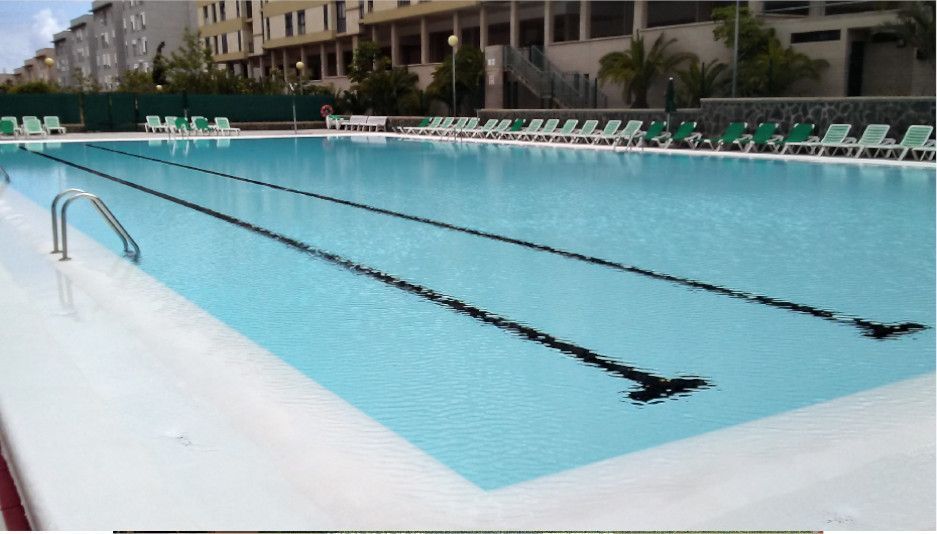 Una gran piscina con muchas sillas alrededor.