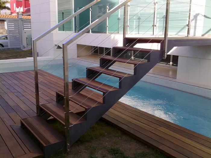 Un conjunto de escaleras de madera que conducen a una piscina.