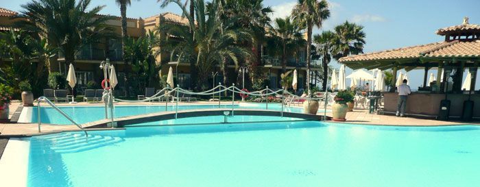 Una gran piscina rodeada de palmeras y edificios.