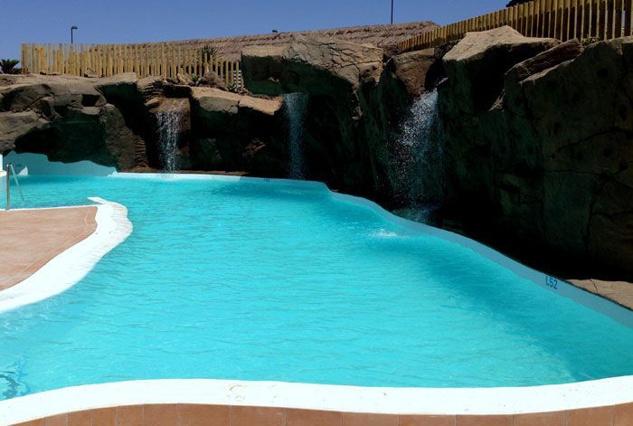 Una gran piscina con una cascada al fondo.