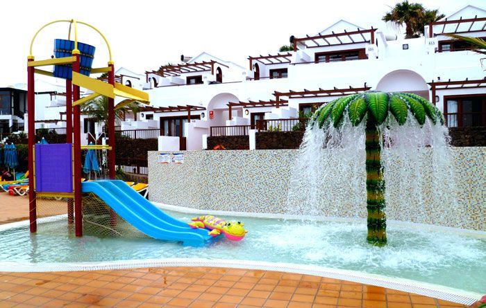 Un parque acuático con un tobogán y una palmera.