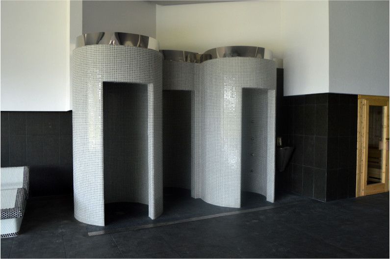 Un baño con ducha y una sauna al fondo.