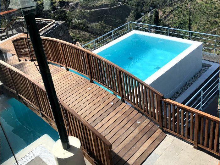 Un puente de madera que conduce a una gran piscina.