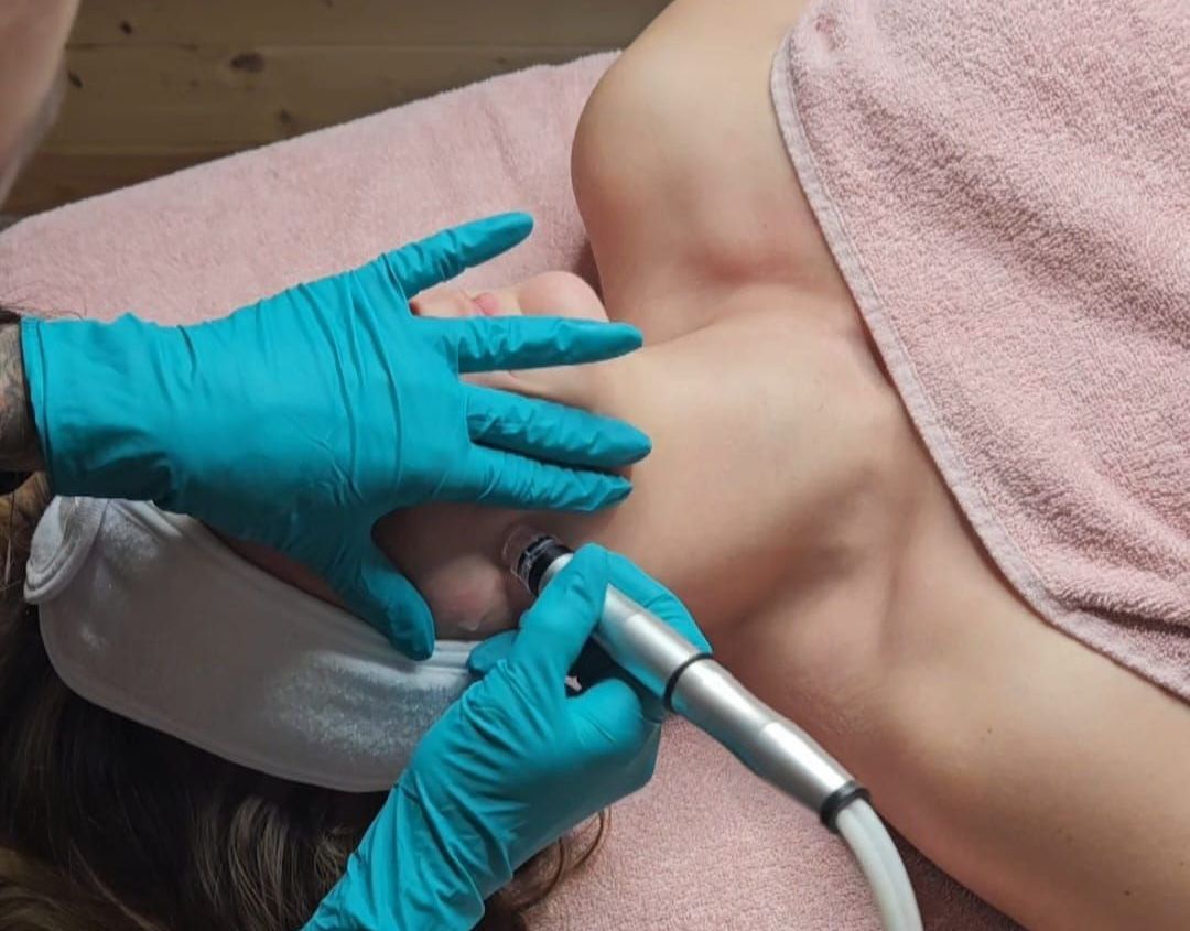 Eine Frau bekommt in einem Spa eine Gesichtsbehandlung und trägt dabei blaue Handschuhe.