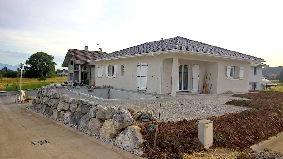 Enrochement de soutènement pour installation de piscine devant une maison