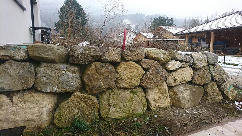 Mur de soutènement en pierre dans un décor extérieur enneigé