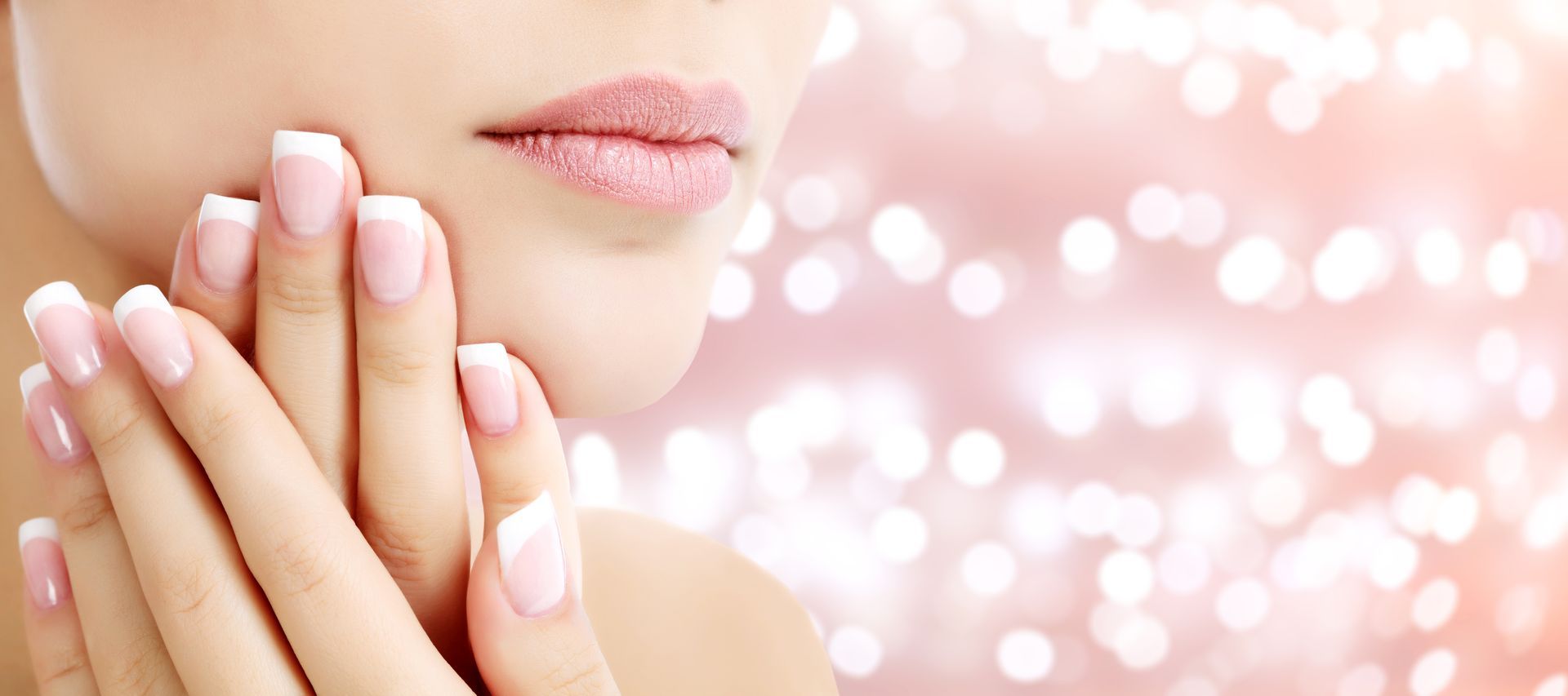 Hände mit French Manicure über Nagellackfarbmustern.
