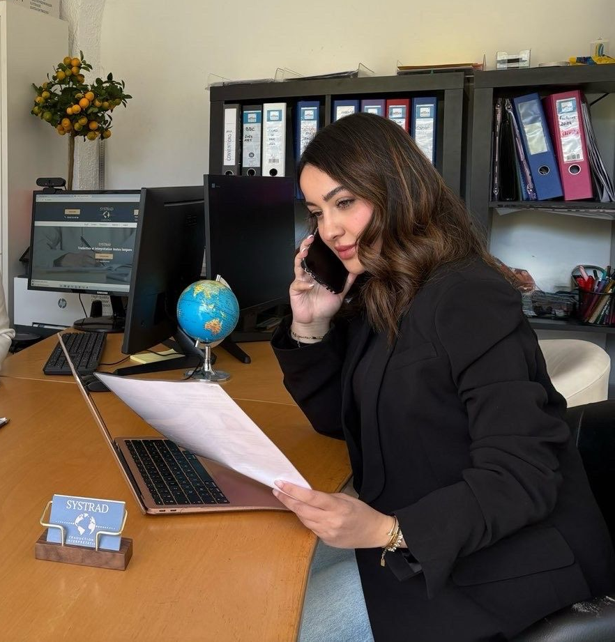 Traductrice assise à son bureau avec un téléphone à la main