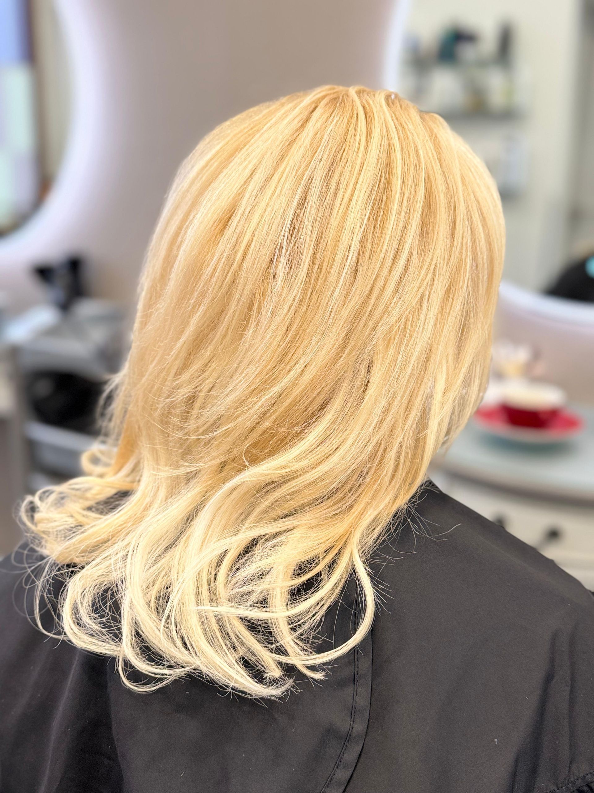 Blondes Haar, Rückansicht, mit Puder bedeckt, in einer Salonumgebung.