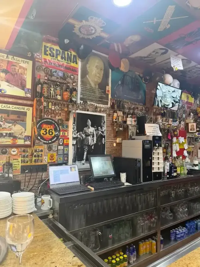 Una pared del bar decorada con carteles, fotos históricas y recuerdos relacionados con la Guerra Civil Española y Franco.