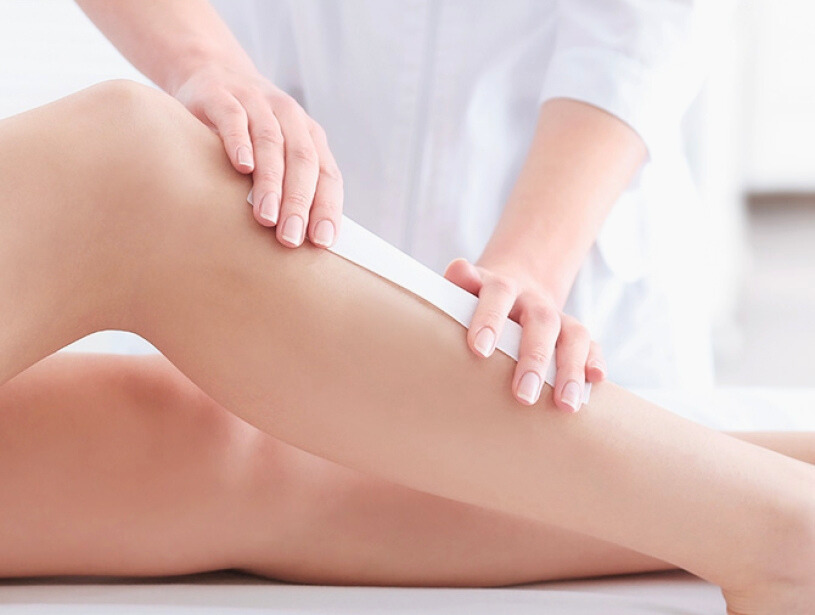 On épile la jambe d'une personne à la cire dans un spa.