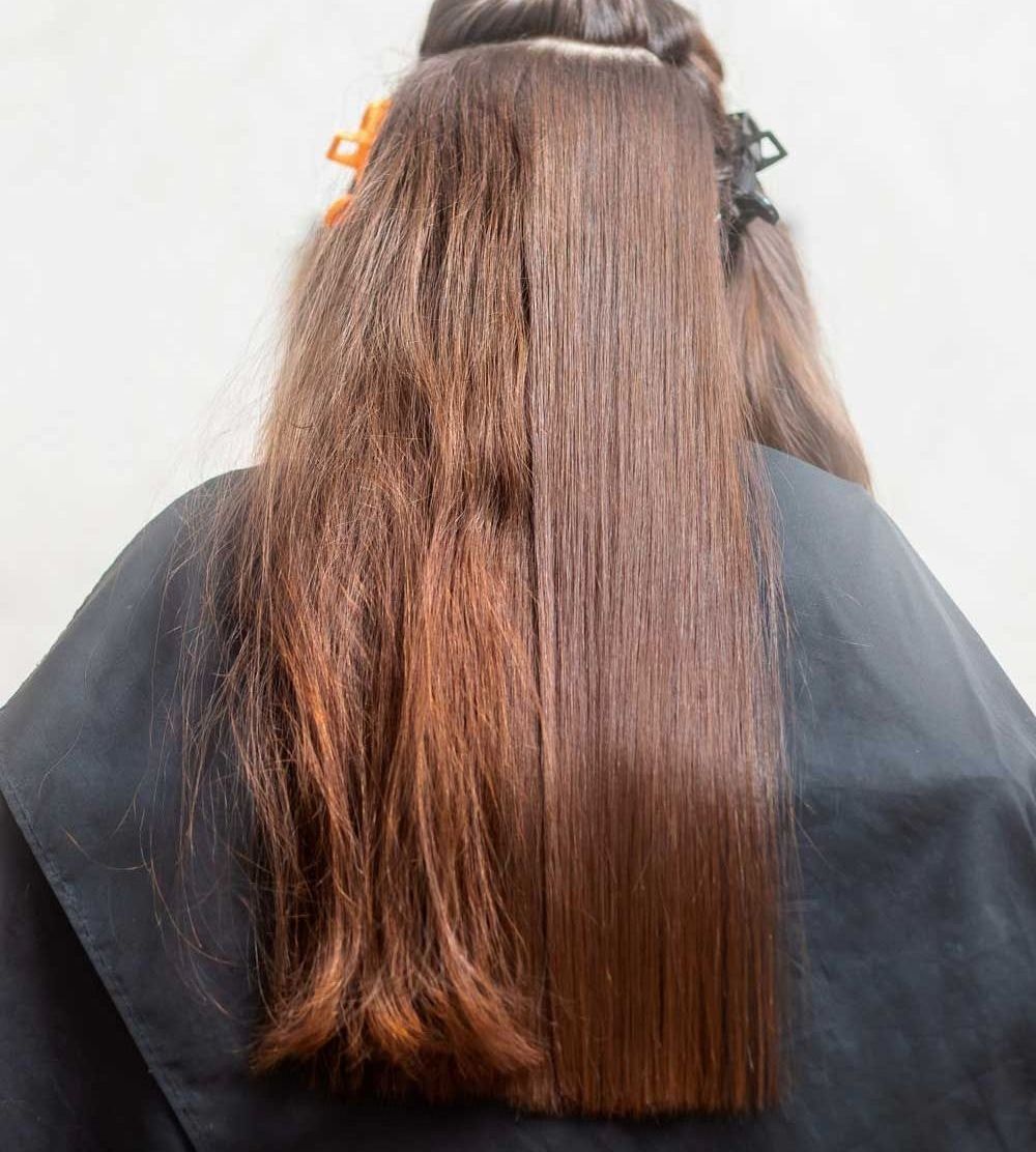 Una mujer con cabello largo y castaño lleva una capa negra.