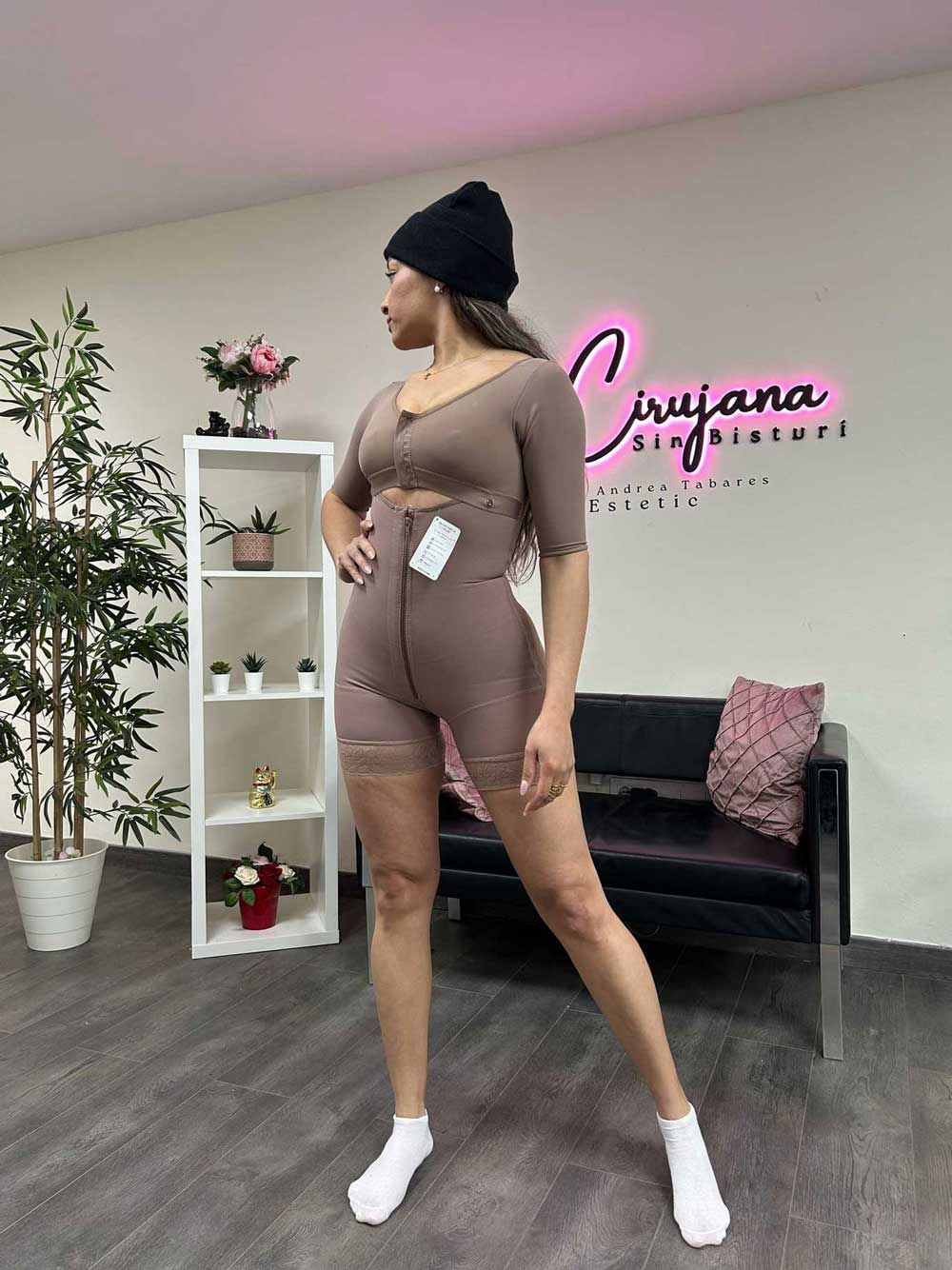 Una mujer está parada frente a un sofá en una habitación.