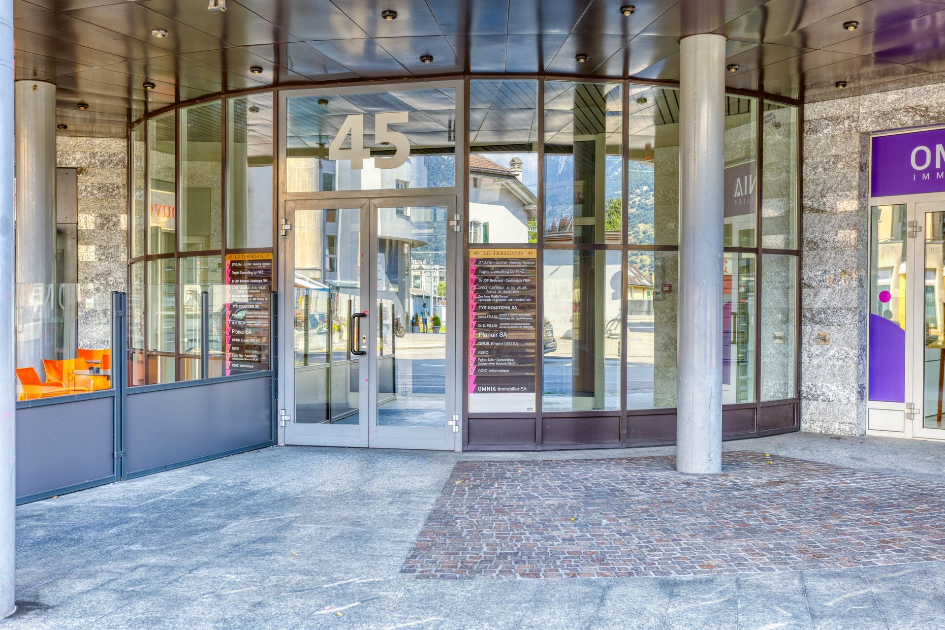 Un grand bâtiment avec beaucoup de fenêtres et un panneau violet qui dit sur.