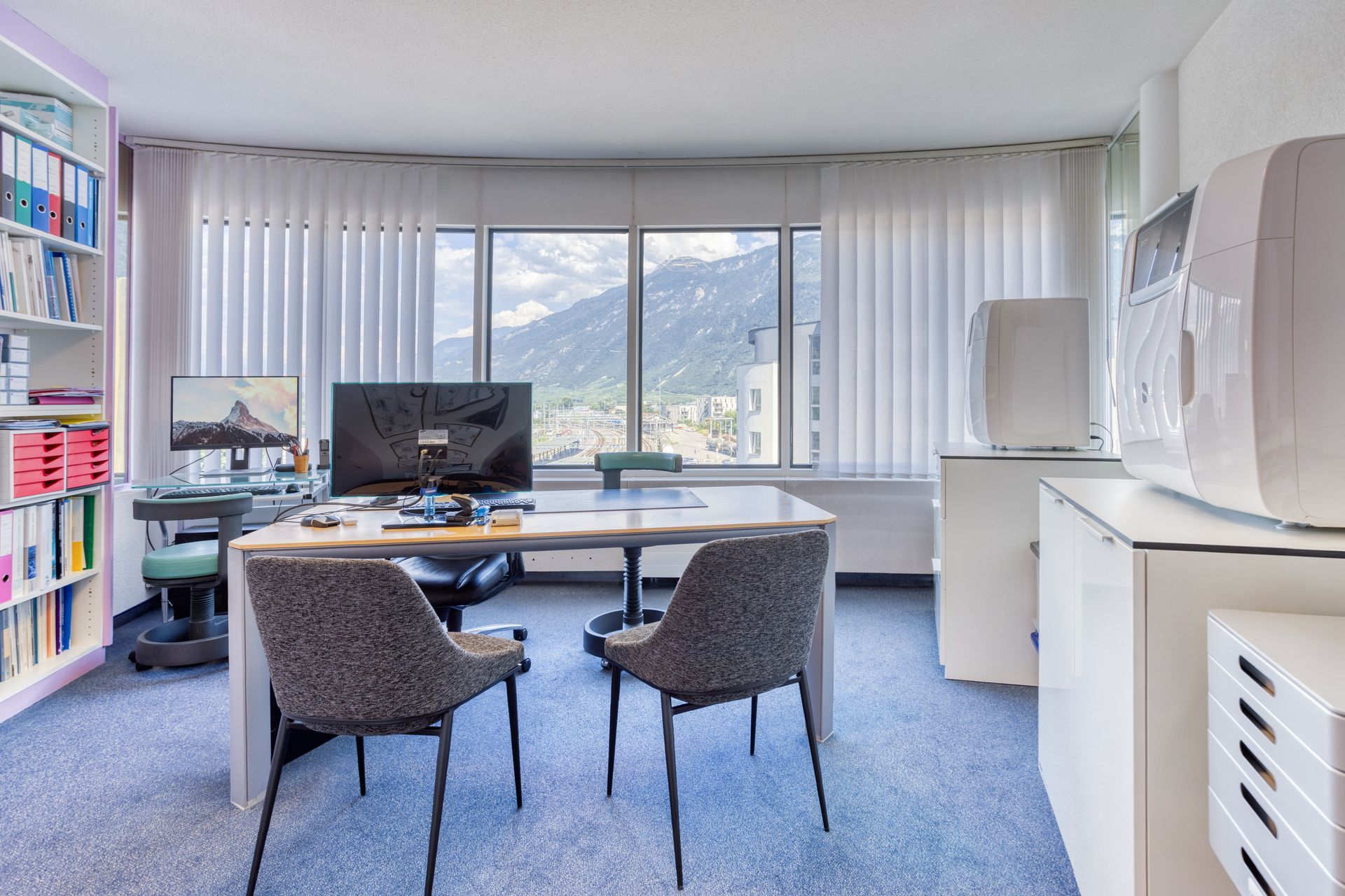 Il y a un bureau avec un ordinateur dessus au milieu de la pièce.