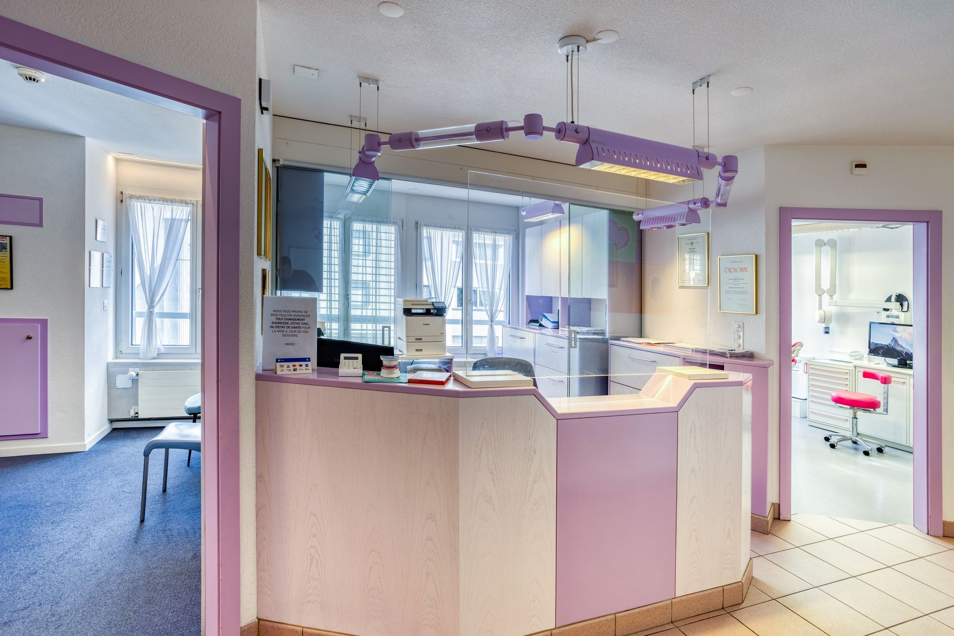 Un bureau d'accueil violet et blanc dans un cabinet dentaire