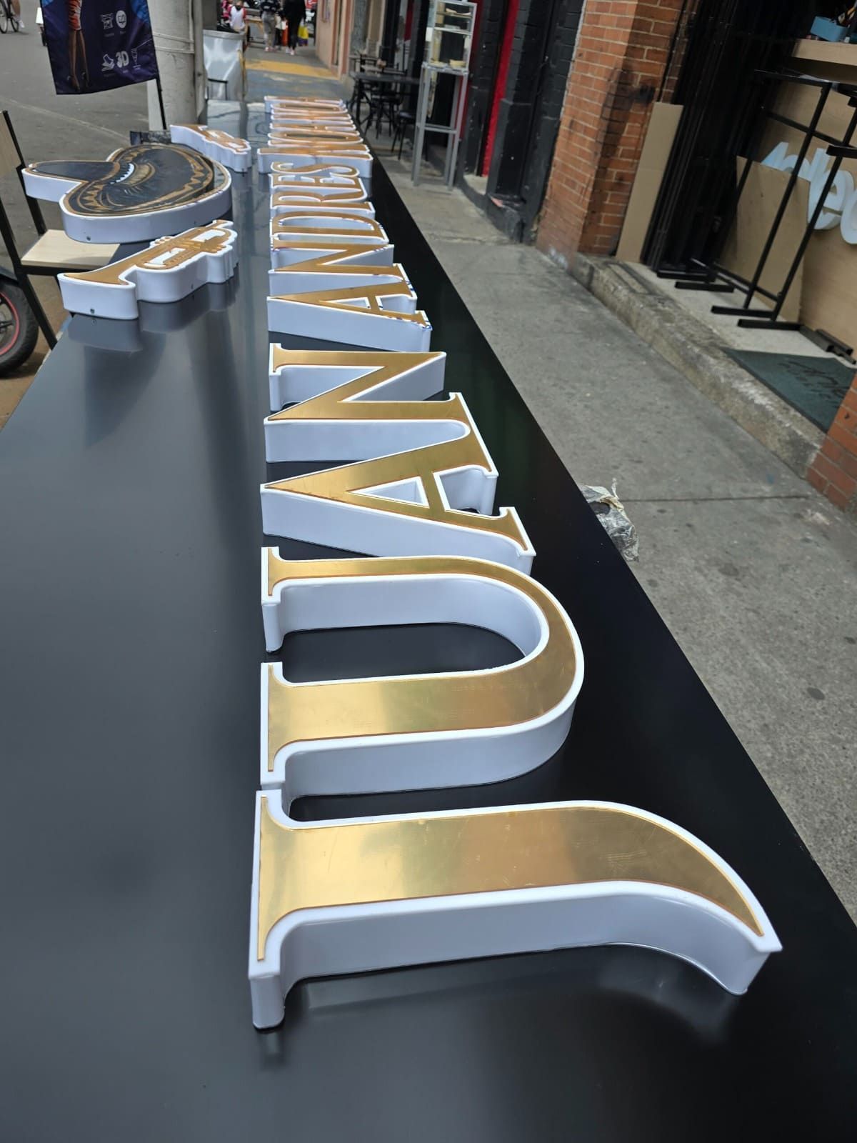 Grandes letras tridimensionales, doradas y con bordes blancos, que forman la palabra