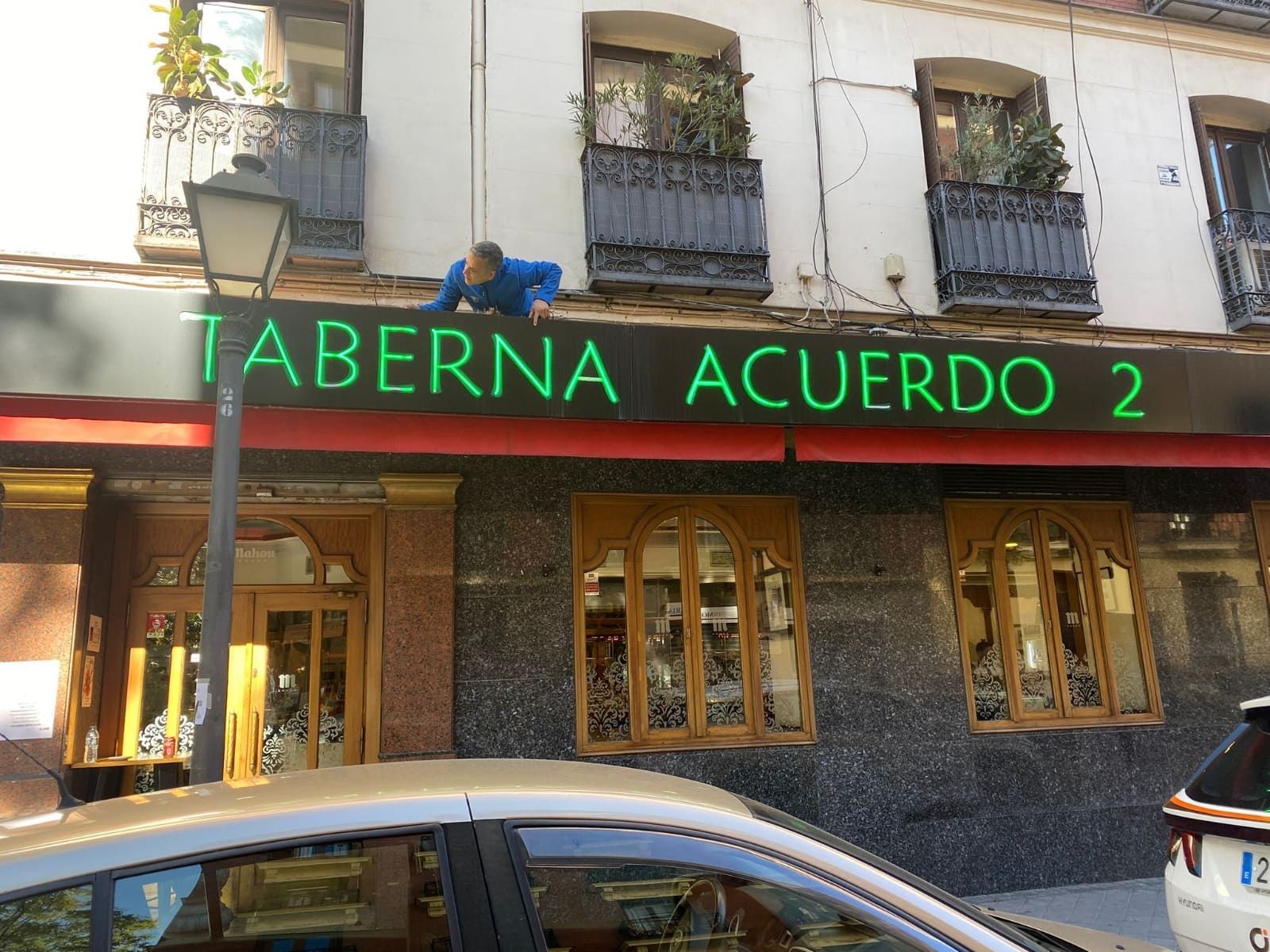 Una persona con una chaqueta azul se inclina sobre el letrero de