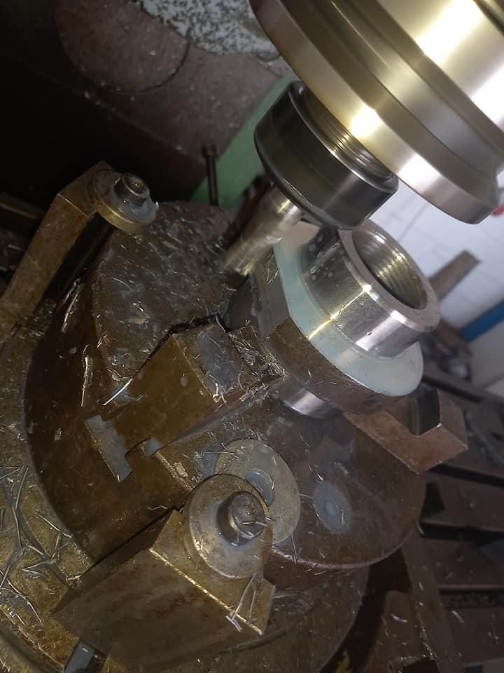 Componente metálico mecanizado por una fresadora. El componente se sujeta mediante un tornillo de banco.