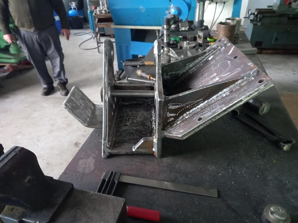 Fabricación de metal soldado en un banco de trabajo; una persona está en el fondo.