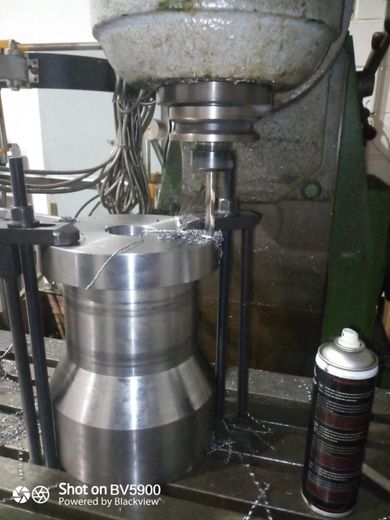 Una pieza de metal perforada por una fresadora en un taller.