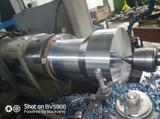 Torno que corta metal, creando virutas metálicas.