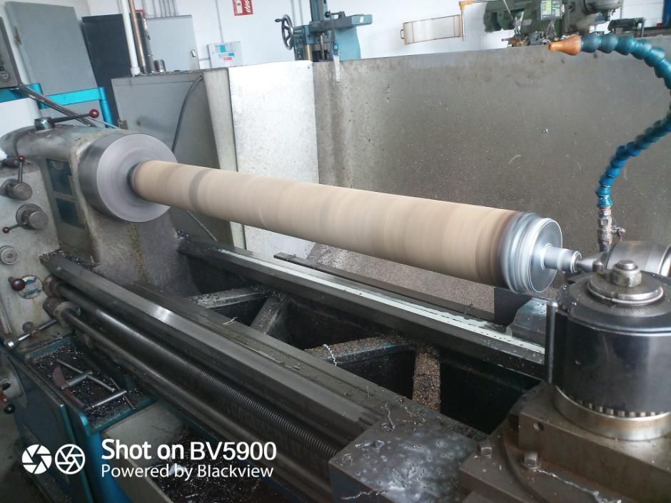 Un objeto cilíndrico que se mecaniza en un torno de metal en un taller.