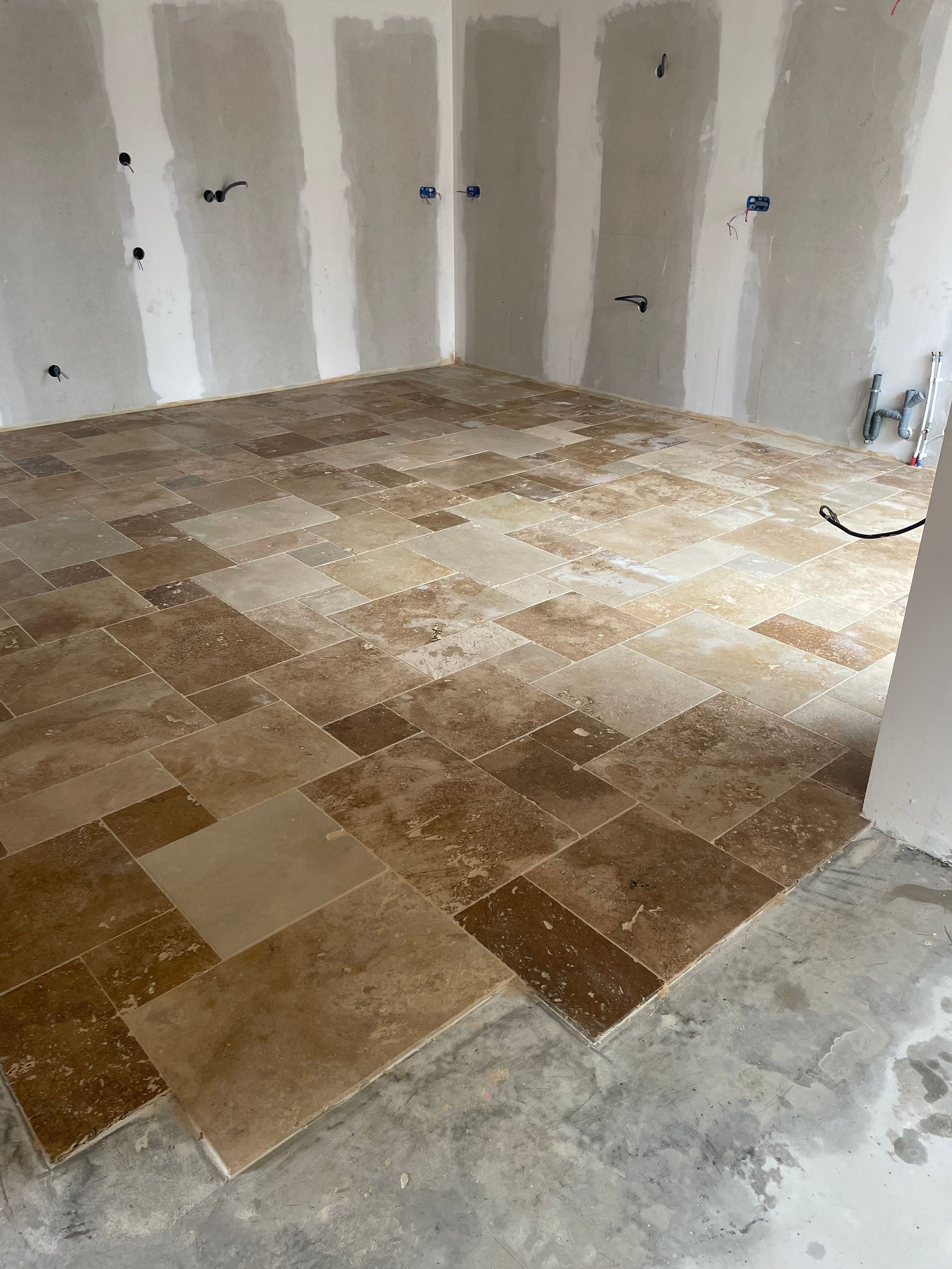 Pose de carrelage dans une maison en construction