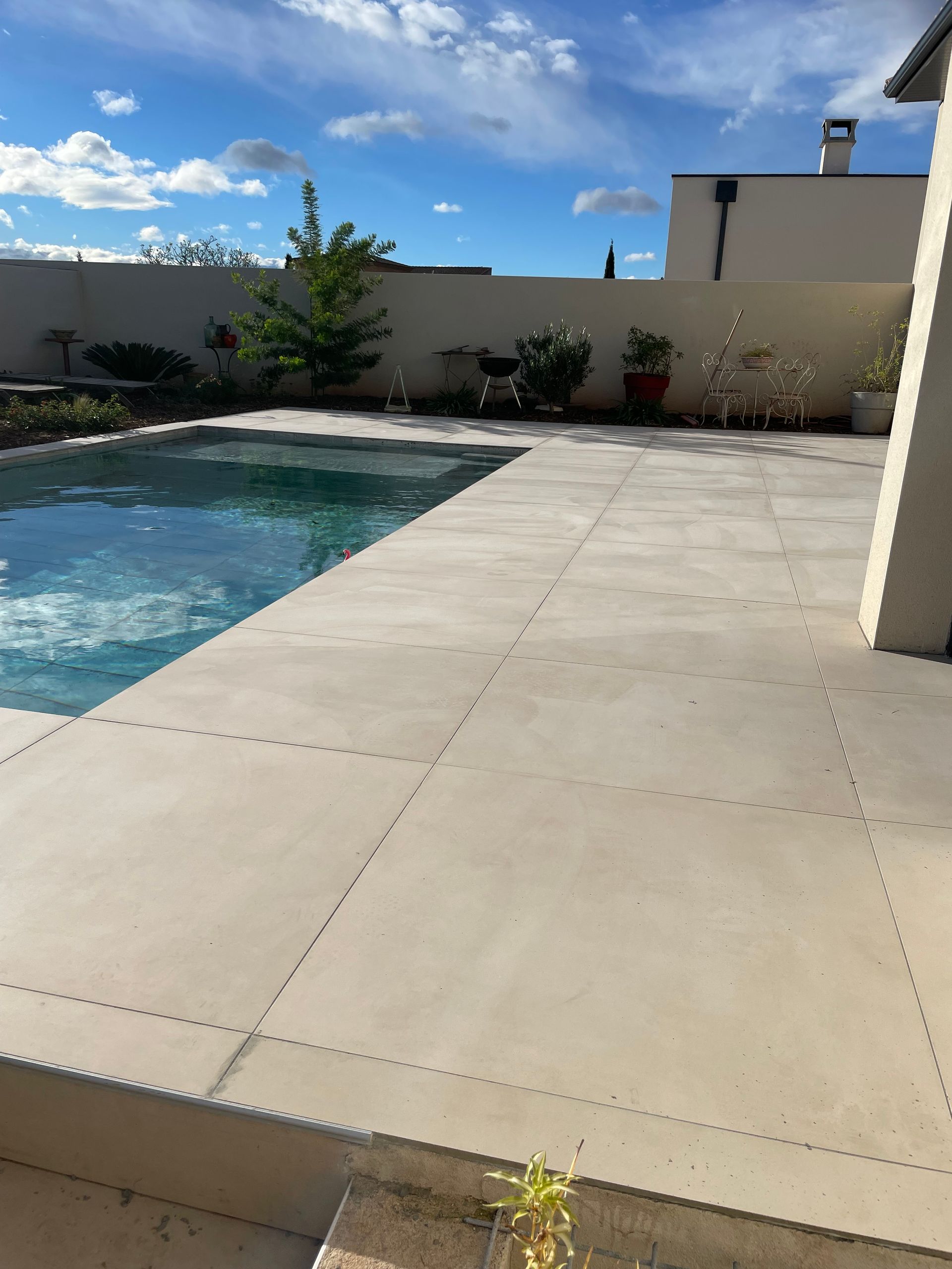 Pose de carrelage : grands carreaux pour une plage de piscine