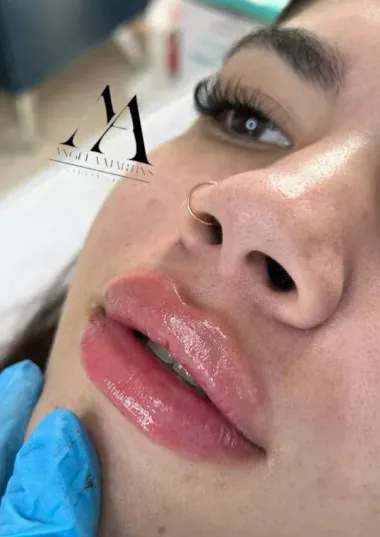 Un primer plano de los labios de una mujer con un anillo en la nariz.
