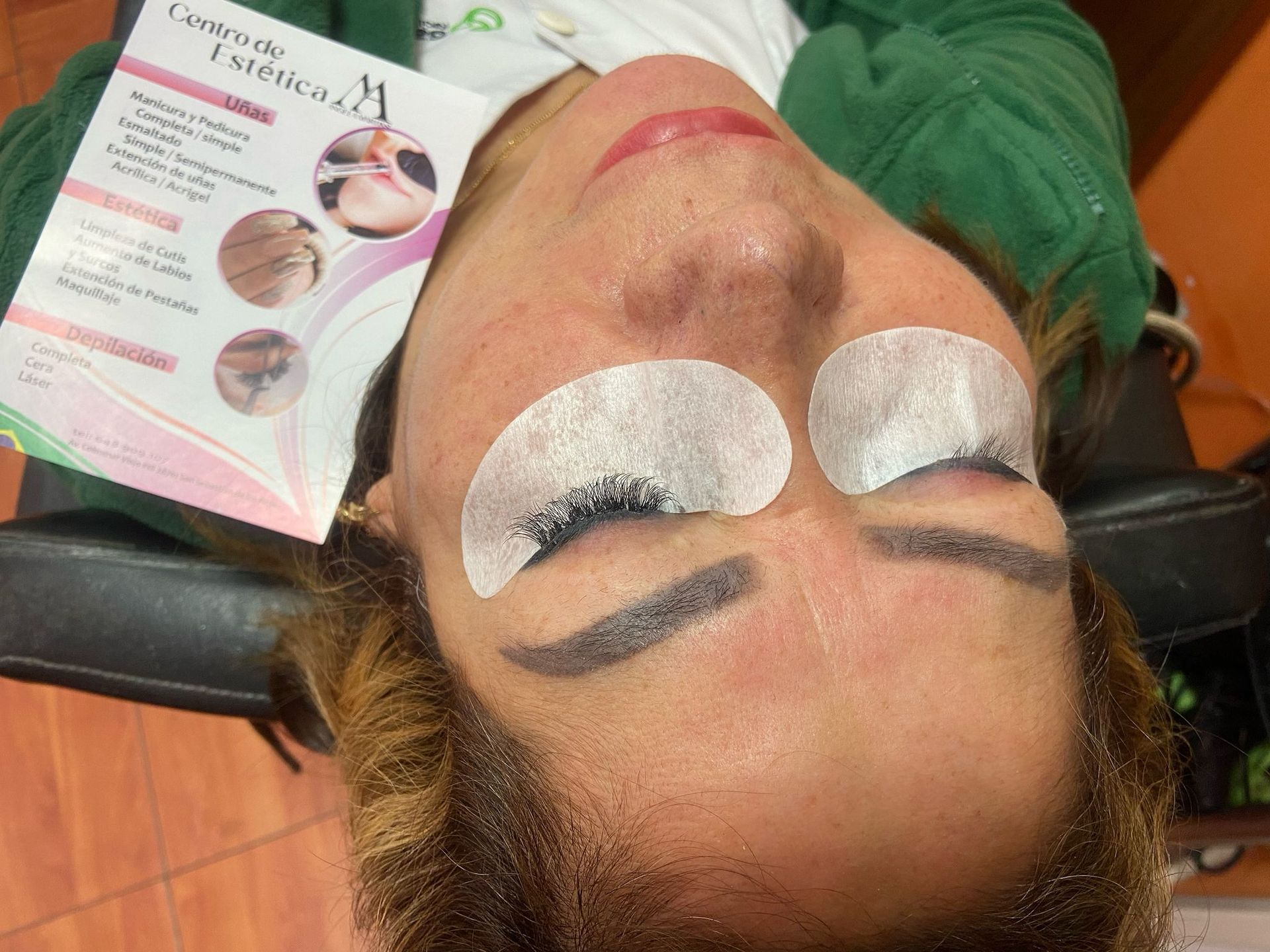 Una mujer se está haciendo las pestañas en un salón de belleza.