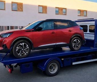 Un hombre está usando un gato para cambiar una llanta de un automóvil.