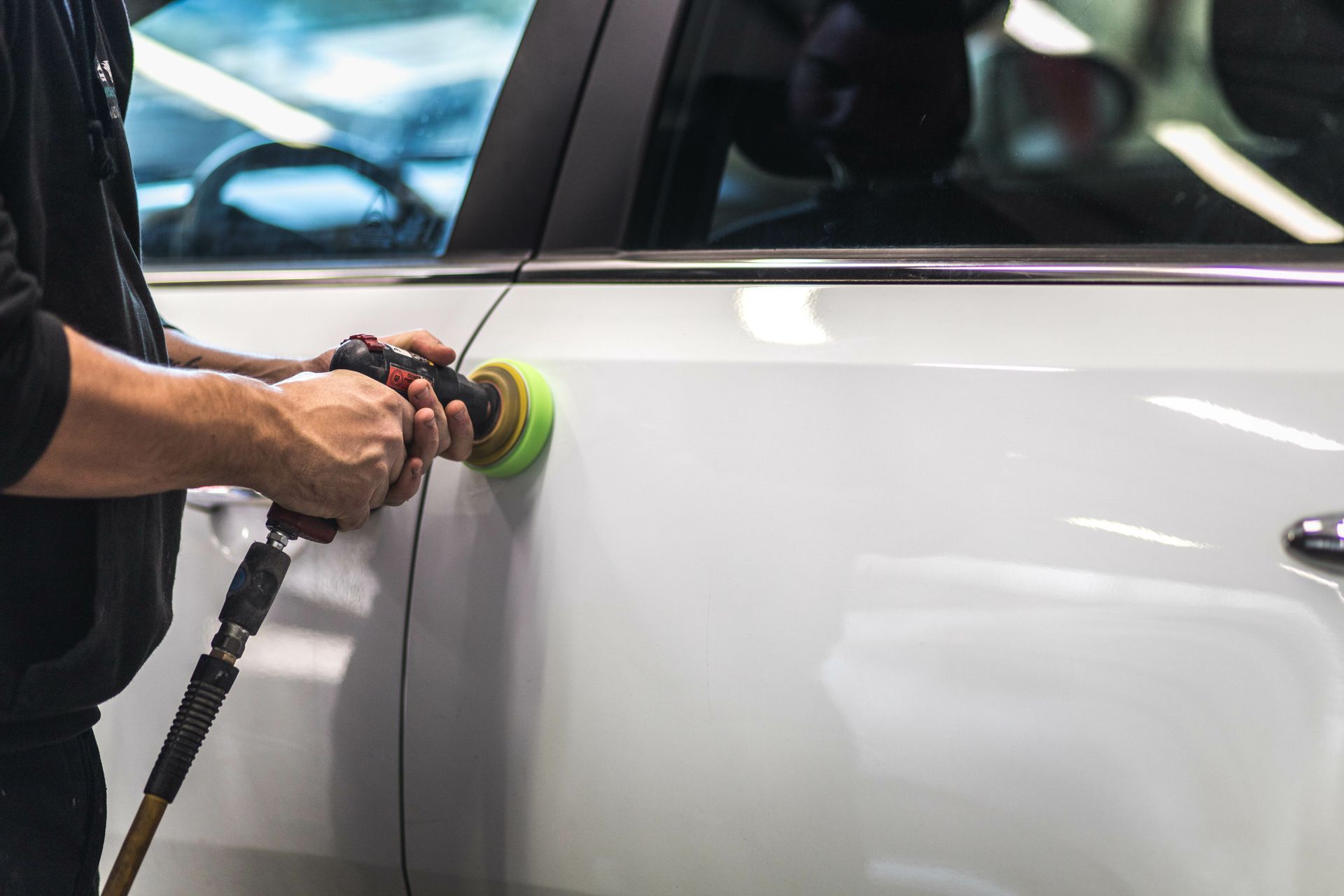 Travaux de carrosserie sur une voiture blanche.