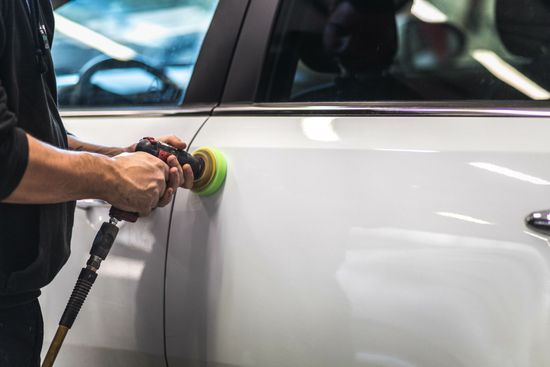 Travaux de carrosserie sur une voiture blanche.
