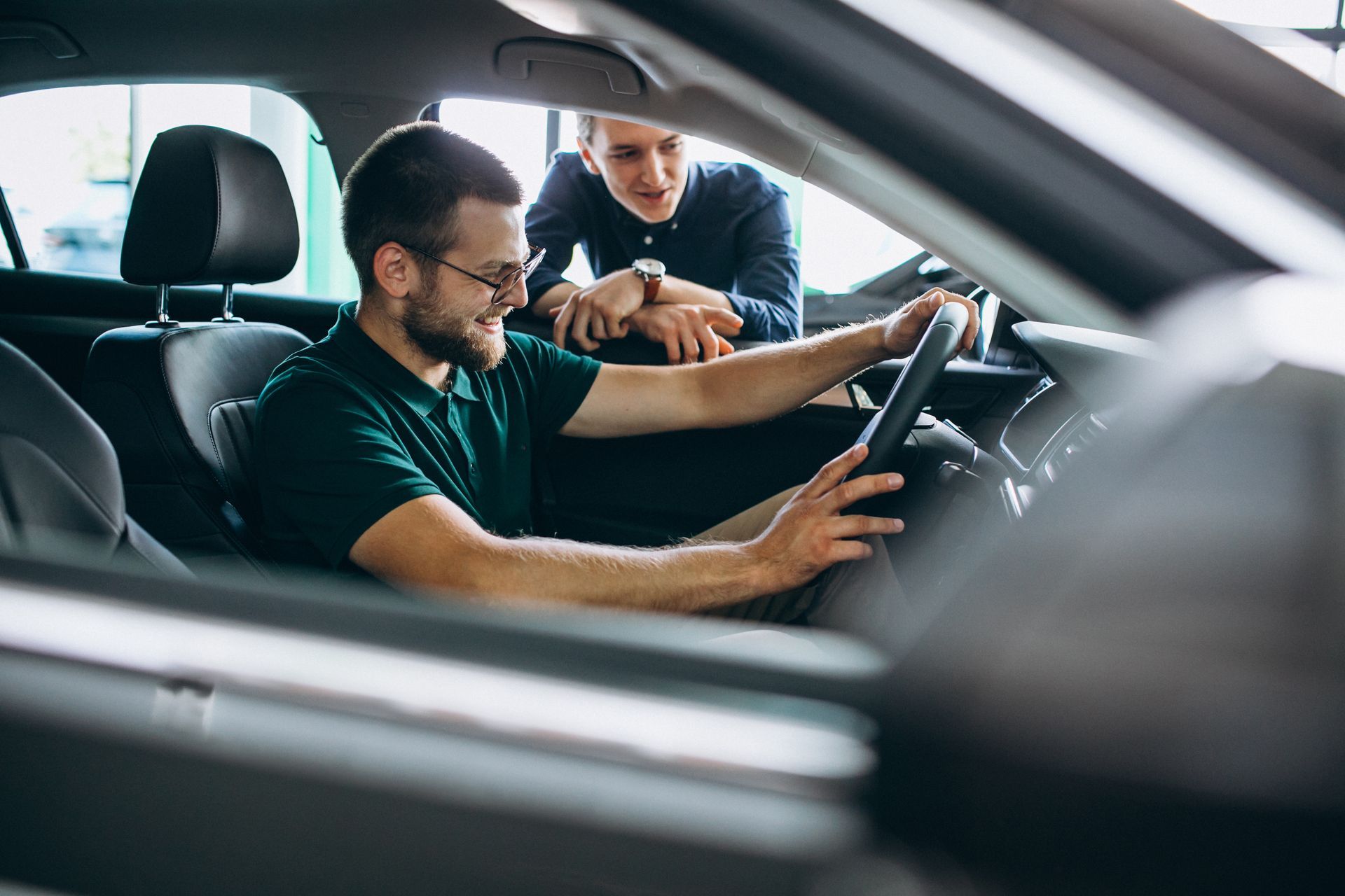 Un conducteur utilise une voiture tandis qu'un passager pointe du doigt le tableau de bord.