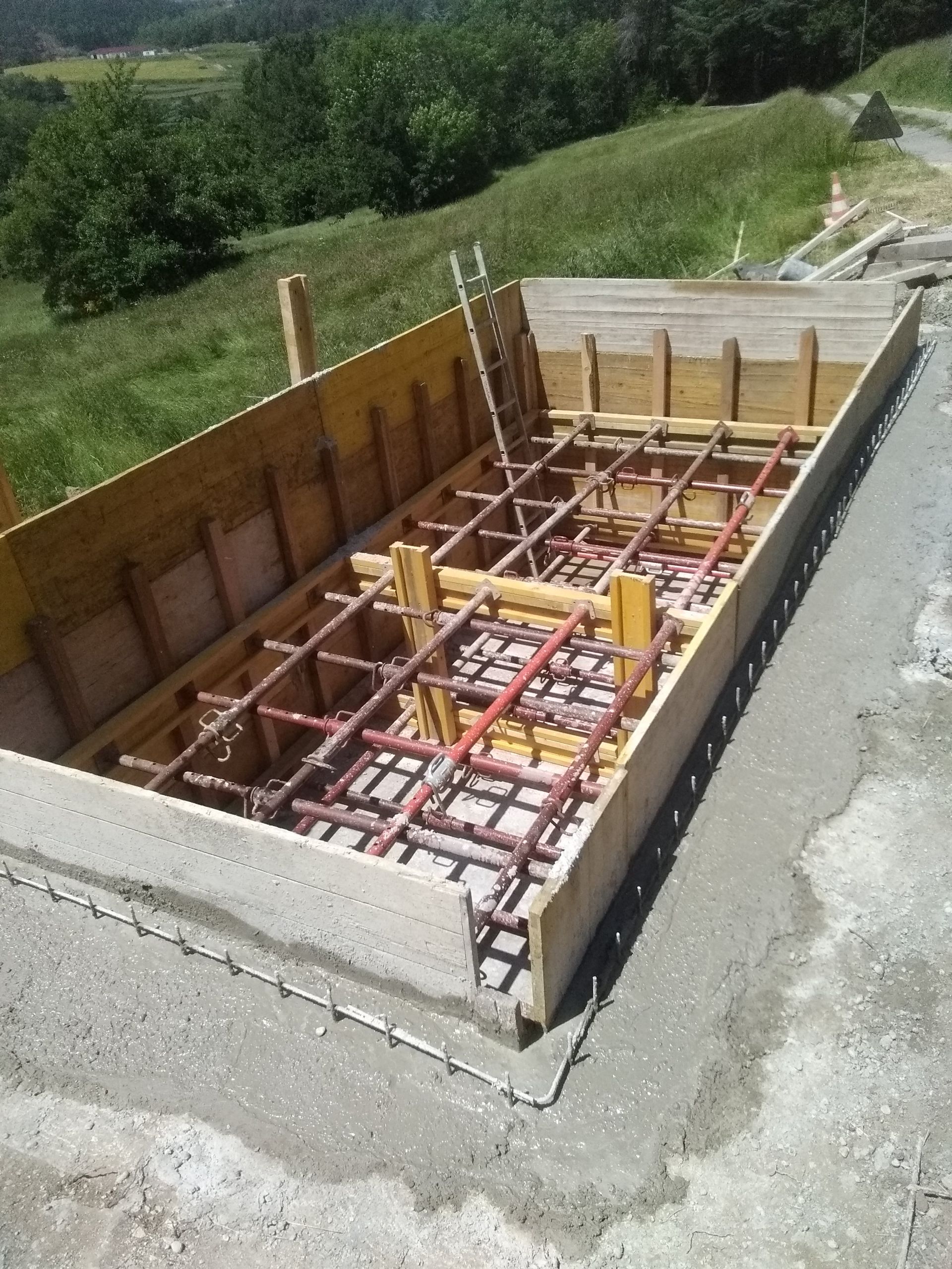 Coffrage de fondation en béton armé et supports en bois sur un chantier routier