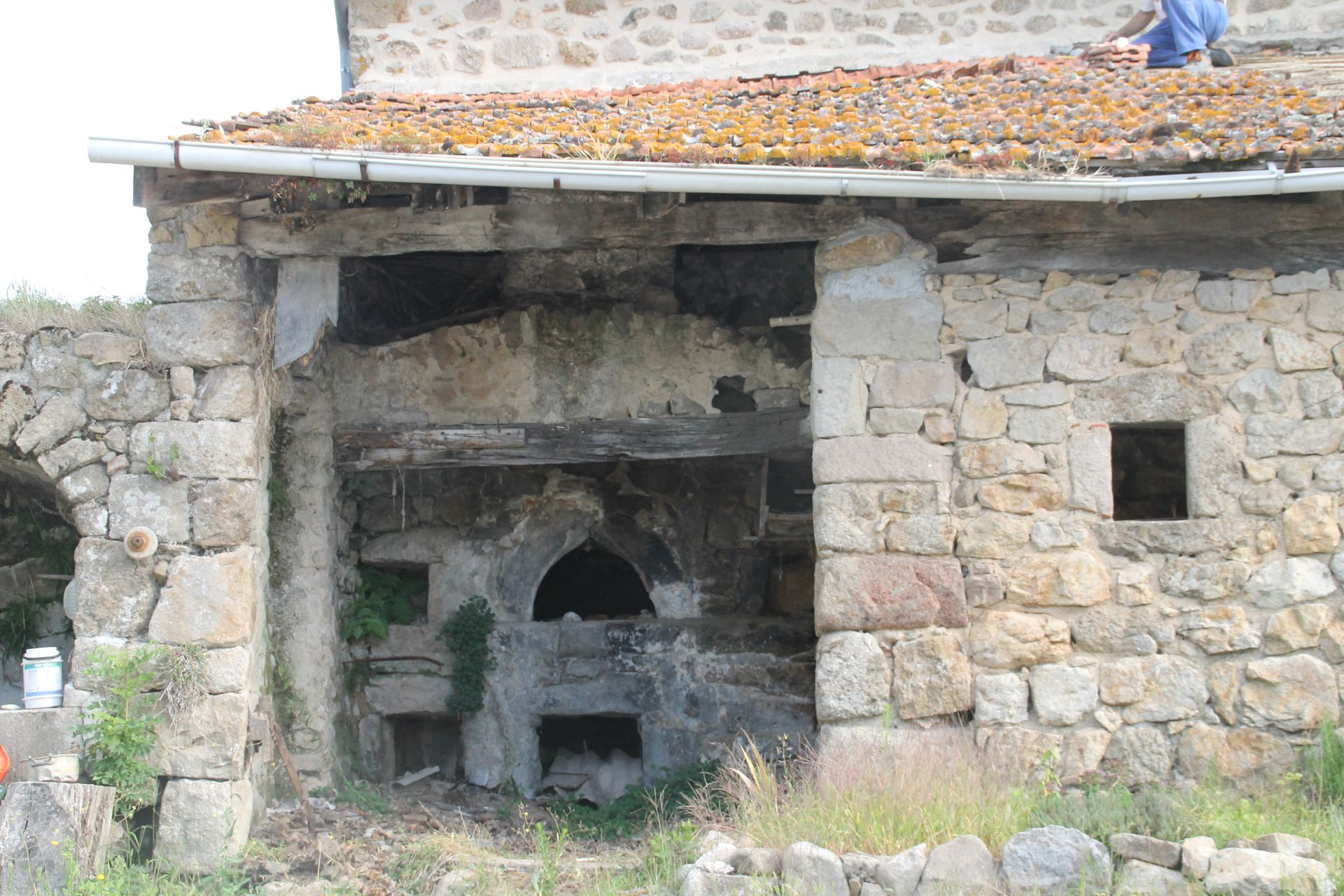 Four rustique en pierre dans un vieux bâtiment en pierre avec une ouverture cintrée et une petite fenêtre carrée.