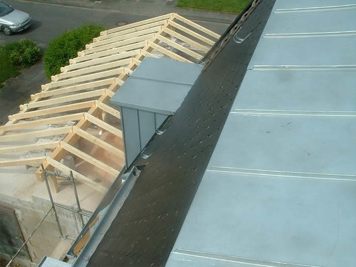 Ein Auto steht am Straßenrand neben einem im Bau befindlichen Gebäude